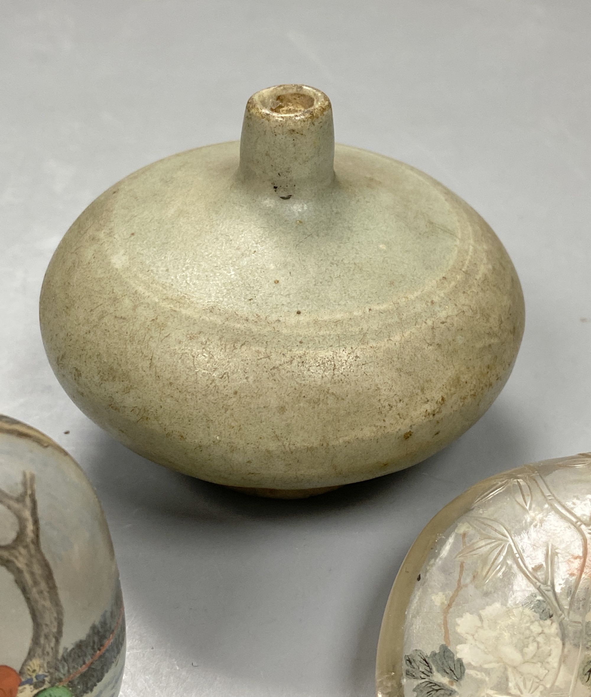 A Chinese inside painted rock crystal snuff bottle and inside painted glass snuff bottle and a small Chinese celadon jarlet, tallest 8c
